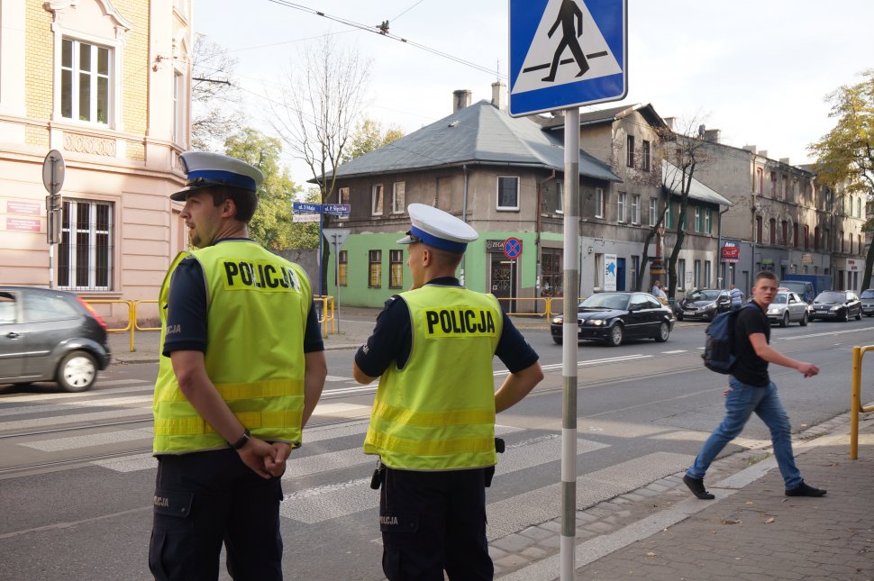 Zdjęcie kolorowe: dwóch umundurowanych policjantów drogówki na ul. 3 Maja w Zabrzu w rejonie oznakowanego przejścia dla pieszych