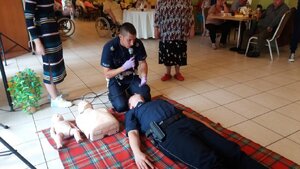 Policyjny ratownik i zabrzańscy dzielnicowi podczas pokazu z udzielania I pomocy przedmedycznej dla seniorów