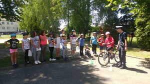 Policjanci ruchu drogowego i uczniowie szkoły podstawowej podczas egzaminu na kartę rowerową