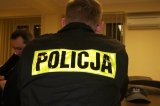 Zdjęcie kolorowe: policjant w umundurowaniu ćwiczebnym na sali odpraw