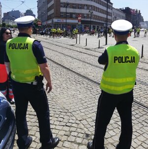 Zdjęcie kolorowe: policjanci zabrzańskiej drogówki w żółtych kamizelkach nadzorujący przejazd rowerzystów