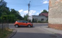 zdjęcie kolorowe: samochód osobowy marki Reanult Captur koloru pomarańczowego zatrzymany na jezdni