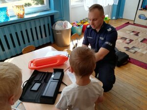 Zdjęcie kolorowe: zabrzański policjant zajmujący sie profilaktyką społeczną podczas spotkania z dziećmi