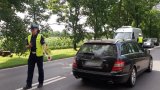Zdjęcie kolorowe: policjant ruchu drogowego w trakcie  kontroli
