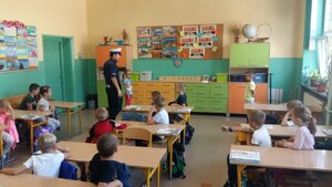 Zdjęcie kolorowe: Policjant podczas prowadzeni prolekcji w ramach akcji "Bezpieczna droga do szkoły"