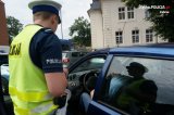 Zdjęcie kolorowe: policjant ruchu drogowego podczas kontroli