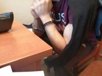 Zdjęcie kolorowe: policjant wykonuje czynności z  zatrzymanym.