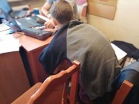 Zdjęcie kolorowe: policjant wykonuje czynności z  zatrzymanym.