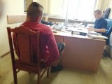 Zdjęcie kolorowe: policjant wykonuje czynności z  zatrzymanym.