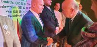 Zdjęcie kolorowe: policjant otrzymuje medal honorowego krwiodawstwa