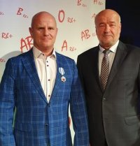 Zdjęcie kolorowe: policjant otrzymuje medal honorowego krwiodawstwa