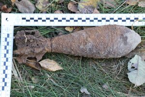 Zdjęcie  kolorowe:  policjanci  podczas zabezpieczenia miejsce  ujawnienia  niewybuchu.