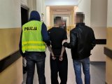 zdjęcie kolorowe: zatrzymany sprawca rozboju wraz policjantami.