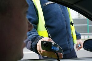 Zdjęcie kolorowe: policjant wykonuje badanie  trzeźwości.