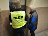 Zdjęcie kolorowe:  zatrzymany nietrzeźwy kierowca i policjant