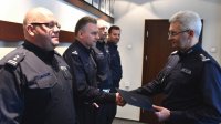 zdjęcie kolorowe: Zastępca Komendanta Wojewódzkiego Policji w Katowicach insp. Mariusz Krzystyniak wręcza powołanie na  nowe stanowisko podinsp. Jackowi Nowakowi i nadkom. Jarosławowi Bąkowi