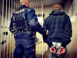 zdjęcie kolorowe: policjant z zatrzymanym mężczyzną podejrzanym o rozbój
