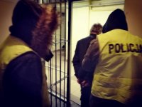 zdjęcie kolorowe: policjancie prowadzą zatrzymanego