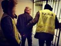zdjęcie kolorowe: policjancie prowadzą zatrzymanego