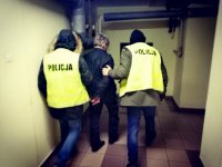 zdjęcie kolorowe: policjancie prowadzą zatrzymanego