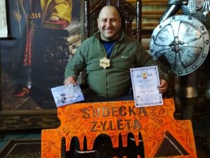 zdjęcie kolorowe:  podkom. Seweryn Kolanek po ukończeniu sudeckiej żylety z pamiątkową żyletą koloru pomarańczowego, certyfikatem ukończenia i medalem.