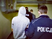 Zdjęcie kolorowe: policjanci prowadzą dwóch zatrzymanych