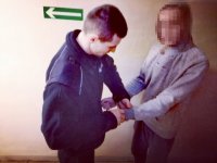 Zdjęcie kolorowe: policjanci mundurowy zakłada kajdanki zatrzymanemu