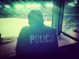 Zdjęcie kolorowe: policjant obserwuje przebieg imprezy sportowej ze stanowiska dowodzenia