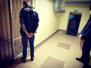 Zdjęcie kolorowe: policjant i zatrzymany sprawca uszkodzenia mienia