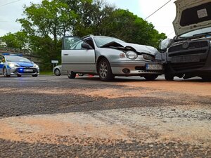 zdjęcie kolorowe: policjanci wykonują czynności na  miejscu kolizji dwóch samochodów osobowych.