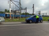 Zdjęcie kolorowe:  funkcjonariusze SOK rozmawia z kierowcą niebieskiego samochodu podczas działań &quot;bezpieczny przejazd&quot;