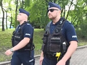 Zdjęcie kolorowe: dwóch policjantów, jeden z nich ma przeciwsłoneczne okulary
