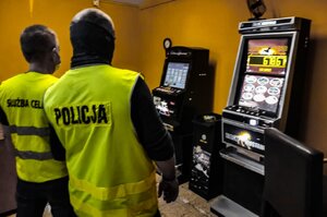 Zdjęcie kolorowe: policjanci podczas likwidowania punktu z nielegalnymi automatami.
