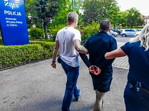 zdjęcie kolorowe: policjanci z zatrzymanym mężczyzną