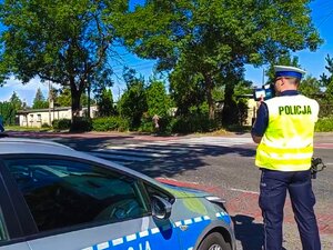 Zdjęcie kolorowe: policjant wykonuje pomiar predkości