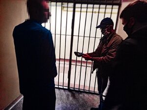 Zdjęcie kolorowe: policjanci KMP Zabrze prowadzą zatrzymanego mężczyznę w kajdanach zespolonych.