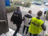 zdjęcie kolorowe: policjanci prowadzą zatrzymanego mężczynę