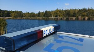 Policyjne sygnały radiowozu, w tle zbiornik wodny