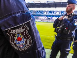 Naszywka Komisariatu II Policji w Zabrzu w tle trybuny  na Stadionie Górnika Zabrze
