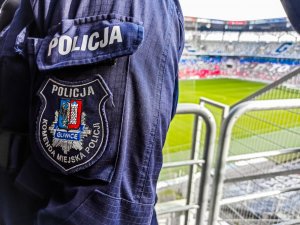 Naszywka Komendy Miejskiej Policji w Gliwicach w tle trybuny  na Stadionie Górnika Zabrze