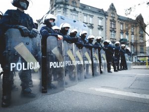 Kordon policjantów z opuszczonymi tarczami