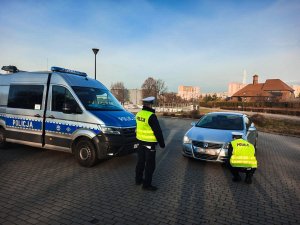 Policjanci podczas  akcji Twoje światła - Nasze bezpieczeństwo na stacji kontroli pojazdów przy sprawdzaniu oświetlenia pojazdu