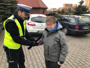Policjanci WRD KMP Zabrze podczas  zabezpieczenia orszaku trzech króli rozdają odblaski