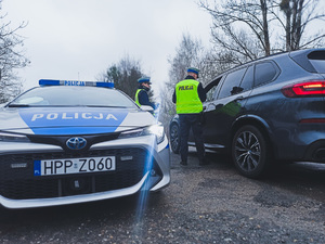Policjanci ruchu drogowego podczas prowadzenia kontroli drogowej na trakcie akcji &quot;Bezpieczny Pieszy&quot;