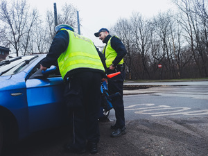 Policjanci ruchu drogowego podczas prowadzenia kontroli drogowej na trakcie akcji &quot;Bezpieczny Pieszy&quot;