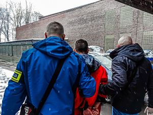 Nieumundurowani Policjanci prowadzą zatrzymanego