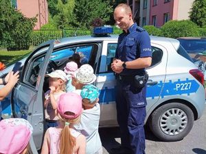 Zdjęcia kolorowe: Umundurowany policjant prowadzący zajęcia profilaktyczne dla przedszkolaków.