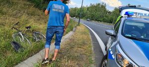 Radiowóz policyjny rower oraz  mężczyzna na  poboczy drogi