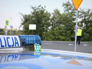 Zdjęcia kolorowe: Umundurowany policjant Wydziału Ruchu Drogowego oraz oznakowany radiowóz Policji.