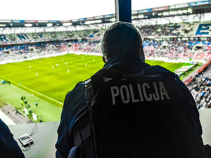 Policjant obserwuje stadion na stanowisku dowodzenia